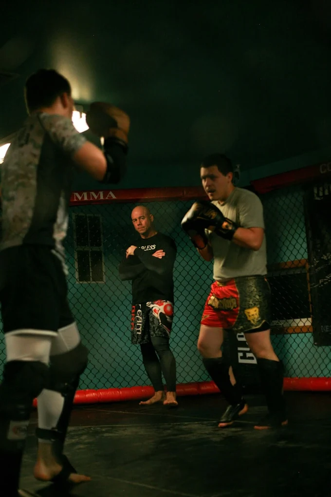 Coach holding mitts for an MMA student at Fearless